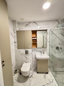 a white bathroom with a toilet and a sink at Bella Vista Pleasure in Baošići
