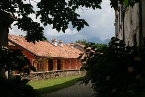 ein Haus mit einem roten Dach und einem Hof in der Unterkunft Agriturismo Casa de Bertoldi in Belluno