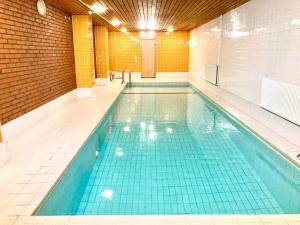 a swimming pool with blue tiles in a building at Moomin Lover Home in Central Helsinki - Pool & Sauna in Helsinki +29 photos