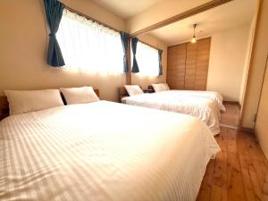 a bedroom with two beds and a window at Good Stay Apartment in Nichinan
