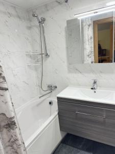 a bathroom with a white tub and a sink and a mirror at Karja 26A-2 in Narva-Jõesuu +11 photos