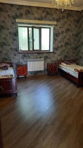 a room with two beds and a wooden floor at Halal House Vip in Qusar