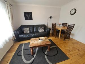 斯坦维尔2 Bedrooms - 3 Beds - Free Parking - 168的客厅里有一张黑色皮沙发和一张桌子