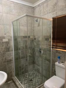 a bathroom with a shower with a toilet and a sink at Cockpit Guest House Kempton Park Airport Getaway in Kempton Park