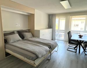 a bedroom with a bed and a table and a dining room at Family friendly duplex with free parking in Leukerbad