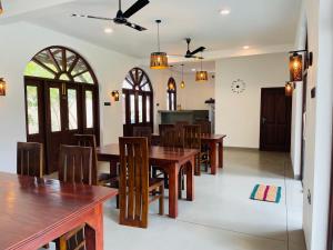a dining room with wooden tables and chairs at The Arch View in Habaraduwa Central