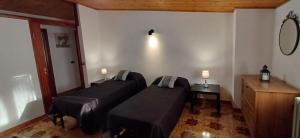 two beds in a room with two lights on the wall at Casa Relax in Centro in Pescasseroli