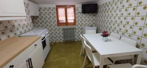 a kitchen with a table and a white table and chairs at Casa Relax in Centro in Pescasseroli