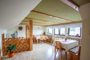 a dining room with tables and chairs in a house at Ferienhof Lailach in Gräfenwarth