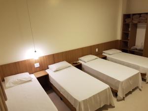 a hospital room with three beds and a light at Oft Place Hotel in Goiânia