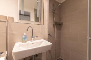 a bathroom with a sink and a shower at Top gelegenes Apartment Dünenstuuv direkt im Zentrum von SPO in Sankt Peter-Ording +9 photos