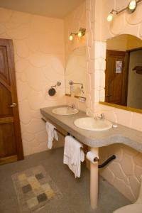 baño con 2 lavabos y espejo grande en Hakuna Matata Amazon Lodge en Archidona