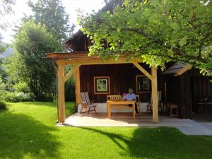 a woman sitting at a table in a gazebo at Chalet Ramsau 8 in Bad Goisern