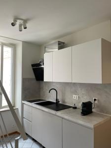 a kitchen with white cabinets and a sink at Torretta House in Locarno