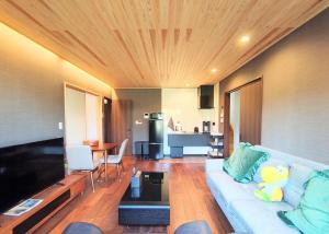 a living room with a couch and a kitchen at Fujiyoshida house, 2 toilet 2 bathroom, Mt Fuji view, 4 living room, free parking 5 cars, projector, washmachine, pet ok in Minamitsuru