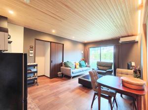 a living room with a couch and a table at Fujiyoshida house, 2 toilet 2 bathroom, Mt Fuji view, 4 living room, free parking 5 cars, projector, washmachine, pet ok in Minamitsuru