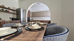 a dining room with a table with chairs and a kitchen at Spacious & Sunlit Charm in Malta! in Siġġiewi