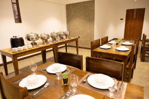 a dining room with tables and chairs with wine glasses at Chaza Oddington in Lindula