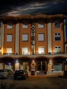 a large brick building with a sign on it at Hotel Villa de Utrillas in Utrillas