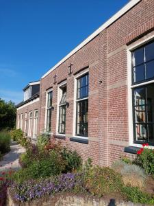 a brick building with flowers in front of it at Suite School 15 A in Zonnemaire