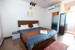 a bedroom with a large bed with a wooden headboard at Shanti krishna Residency Gokarna in Gokarna