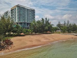 a beach in front of a tall building with a building at PD D'Wharf The Bay Superior Queen Room SeaView Balcony in Port Dickson