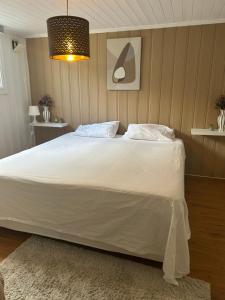 a bedroom with a large white bed with a light at Basement Apartment -Ås Ski in Oslo