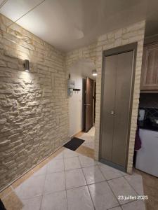 a hallway with a stone wall and a door at Très jolie F2 à 250m de la plage in Courseulles-sur-Mer +8 photos