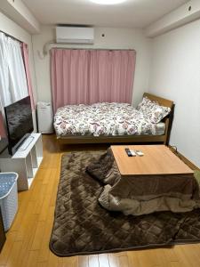 a small room with a bed and a table at 短期賃貸ビッグバーンズマンション田上 in Kagoshima