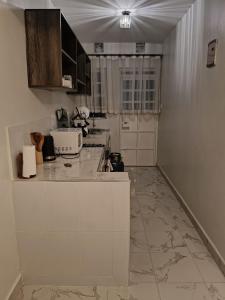 a kitchen with white cabinets and a marble floor at Homely Homes in Eldoret