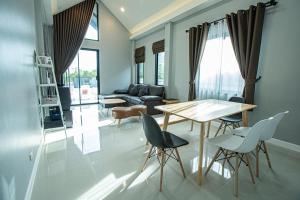 a living room with a table and chairs at Lunar pool villa sattahip in Ban Tao Than