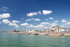 a beach with a bunch of people on the water at Central 3 bedroom apartment with superking and king beds in Bognor Regis