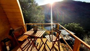 a porch with a bench and two chairs on a deck at Casa da Mata de Fajão in Pampilhosa da Serra