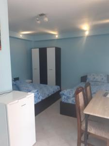 a room with two beds and a table and chairs at Casa Dina in Băile Herculane