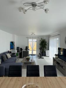 a living room with a blue couch and a table at Villa au calme suréquipée 3 ch 9p maxi in Flainval