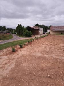 una strada sterrata con un campo sterrato e un edificio di Camping les Petites Roches a Corme-Royal