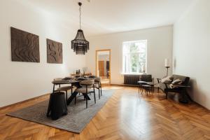 a dining room and living room with a table and chairs at Melnais Dāvids in Liepāja