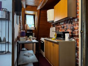 a small kitchen with wooden cabinets and a brick wall at Vikendica Petrovic in Jahorina