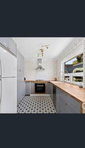 a kitchen with a sink and a stove top oven at Tranquil Coastal Retreat - Renovated 2BR - Sea Views & Sunset Nights in Halletts Cove +7 photos