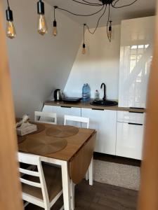 a kitchen with a wooden table and white cabinets at RanyA-Frame in Nucşoara
