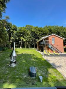 a television on the grass in front of a house at Modernes Haus am See, Ferienhaus Gavner im Seepark Lehe in Wiefelstede
