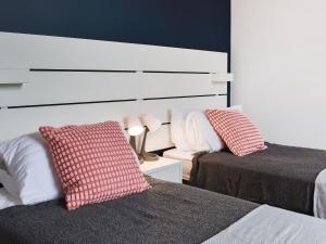 a bedroom with two beds and a white headboard at Bolingey Chapel in Perranporth