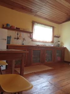 a kitchen with a table and a window in it at Casa da praia in M. Peixe
