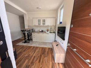 a kitchen with white cabinets and a wooden floor at DAMIEN apartments in Ohrid