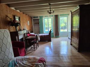 a living room with a kitchen and a dining room at Maison de campagne rustique et confortable in Mazières-en-Gâtine