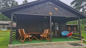 a dog sitting on top of a house with chairs at Chata Ještěrka in Doksy