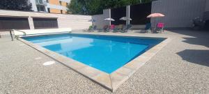 a swimming pool with blue water and chairs and umbrellas at Hotel Baroko in Prague