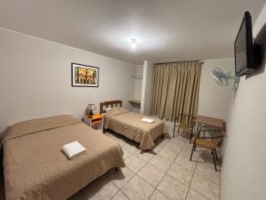 a hotel room with two beds and a tv at Hospedaje el Telar in Nazca +73 photos