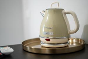 a tea kettle on a stand next to a remote control at Domus Suite in Termoli
