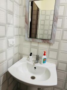 a white sink in a bathroom with a mirror at Room availbale in 2 bhk apartment in Bengaluru
